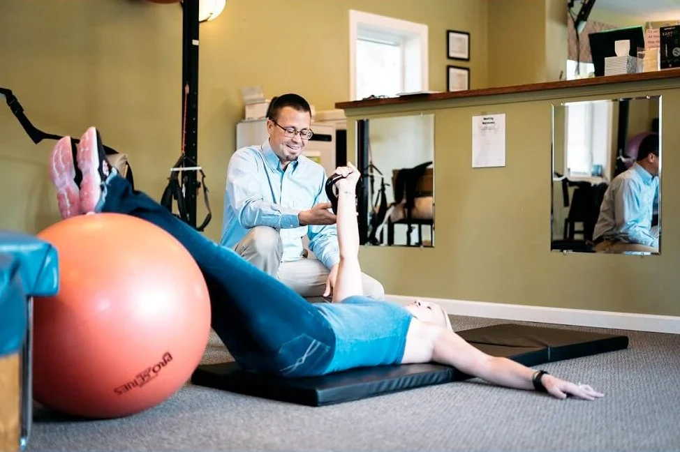 Dr. Kyle Kopicki guiding a patient through a rehabilitation stretch at Keep It Kinetic Chiropractic