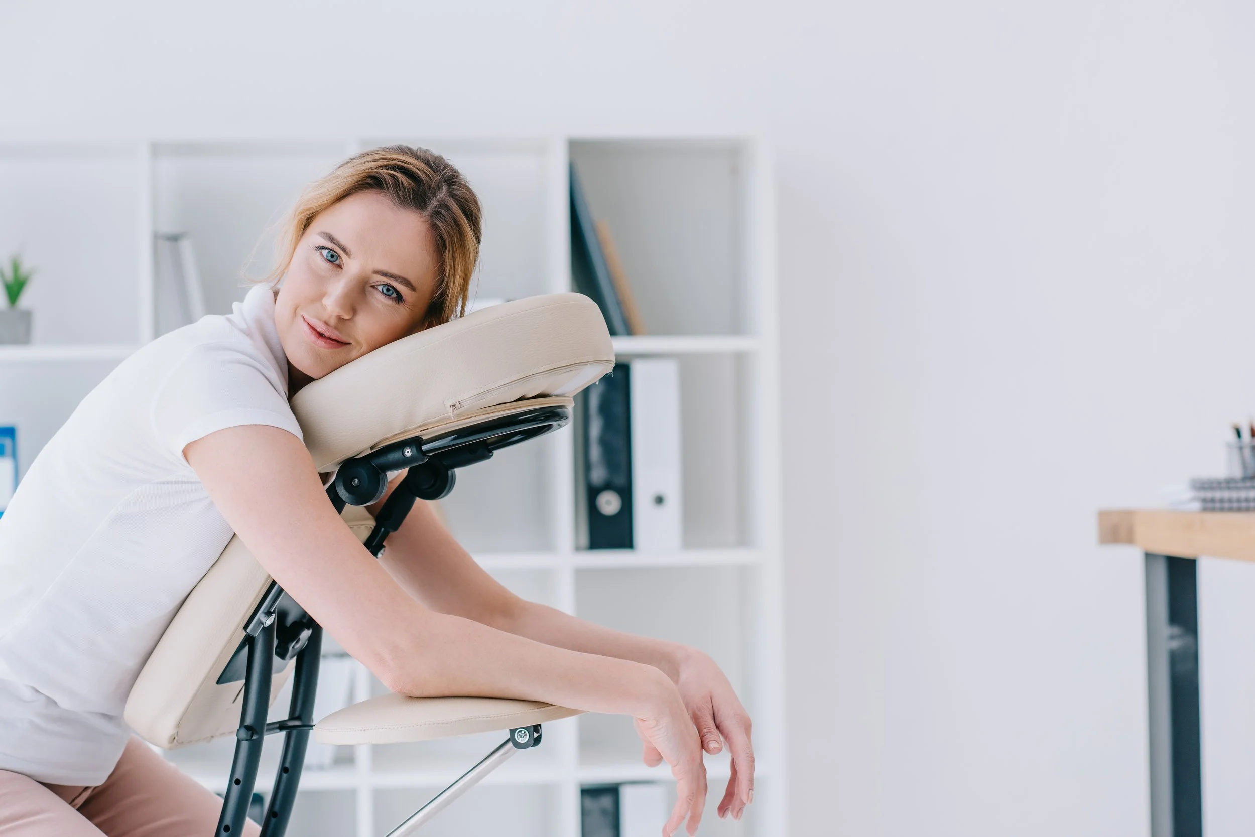 Person seated on a massage chair in an office setting